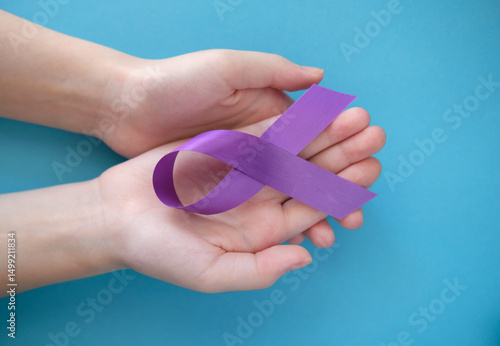 Purple violet symbolic ribbon - the problem of pancreatic cancer, cystic fibrosis, fibromyalgia. Two crossed hands on a blue background
