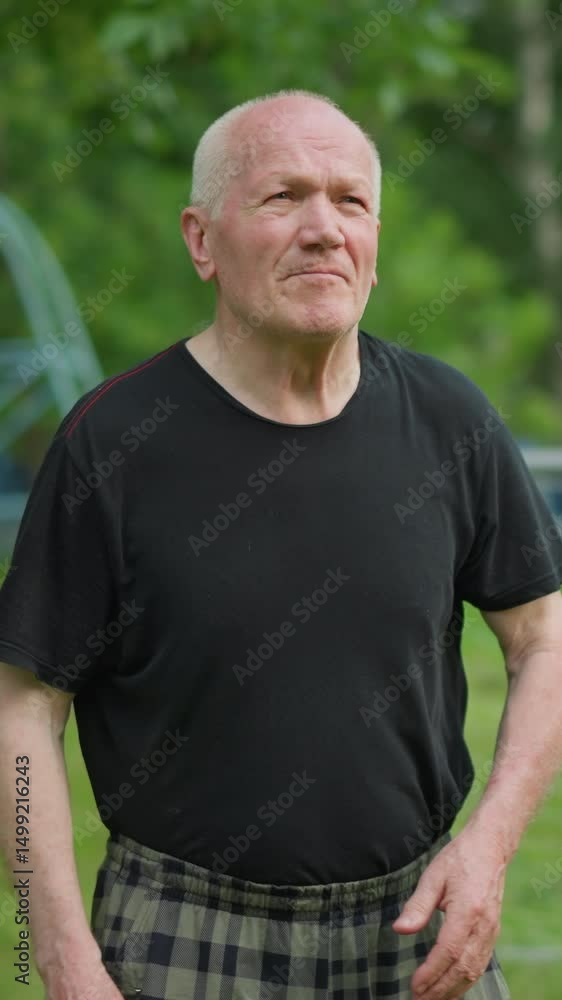An elderly man throws a soccer ball with determination and focus, showcasing his energy and intent, with a blurred background with a goalpost, trees, and a building An elderly man throws a soccer ball with determination and focus, showcasing his energy and intent, with a blurred background with a goalpost, trees, and a building