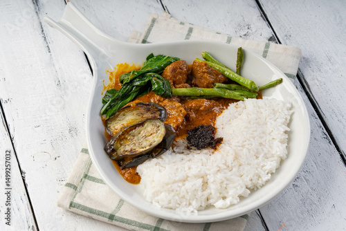 beef or pork stew with eggplant, string beans and pechay topped with shrimp paste also known as Kare-Kare; a famous local Filipino food