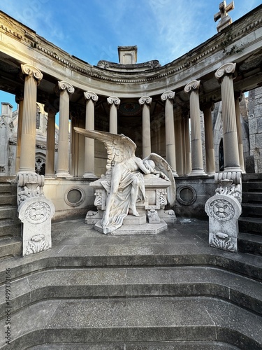 Montjuïc Cemetery in Barcelona at sunset, with dramatic lighting casting long shadows over historic tombstones, crosses, and monuments. A serene yet haunting scene filled with history and symbolism.