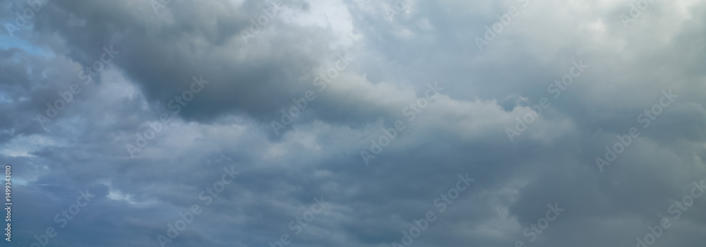 Dark storm clouds gather across the blue sky during the rainy season, forming dramatic shapes as nature signals an approaching storm over the open landscape. Dark storm clouds gather across the blue sky during the rainy season, forming dramatic shapes as nature signals an approaching storm over the open landscape.