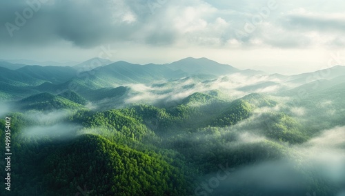 A panoramic view of the Great Smoky Mountains, showing mist-covered hills and lush green forests under an overcast sky.