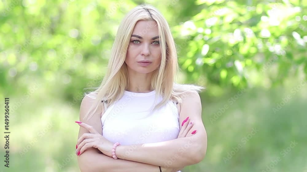 Mature Blonde Woman Standing in Green Park, Looking at Camera, Arms Crossed, Horizontal Video Mature Blonde Woman Standing in Green Park, Looking at Camera, Arms Crossed, Horizontal Video