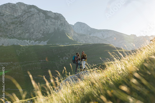 Fotografi Hikers standing on mountain ridge enjoying scenic view