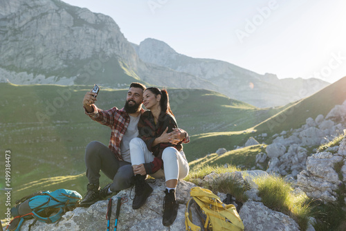 Valokuva Hikers couple taking selfie on mountain top during trekking excursion