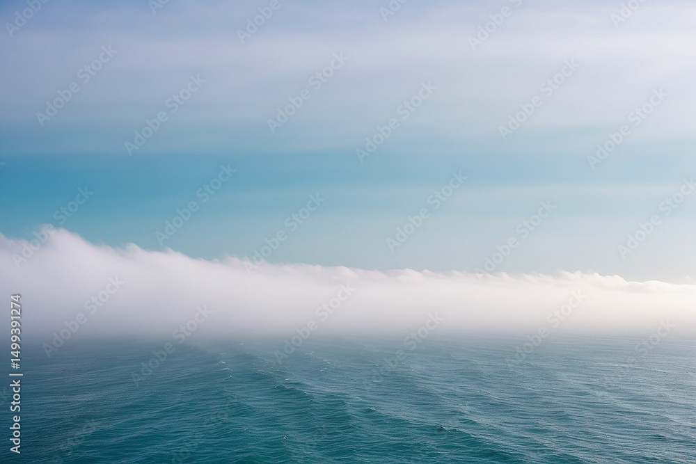Obraz premium White Fog Bank Rolling Across a Teal Ocean Horizon