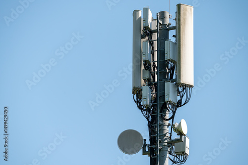 Closeup of antenna array of cellphone mast with aerials and  cabling. Installation. Blue cloudless sky.