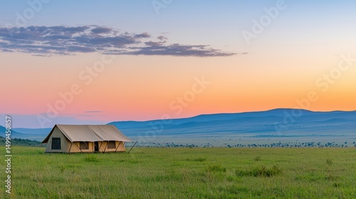 Peaceful tent camp in scenic landscape at dusk with vibrant sunset colors over rolling hills