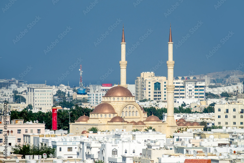 Naklejka premium Oriental architecture. A white Arab city in the foothills against background of dry desert mountains. White sunscreen color. Grand Mosque. Oman
