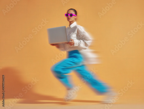 Stylish woman in bright pants and sunglasses dashes across frame with a laptop, captured in dynamic motion blur.

