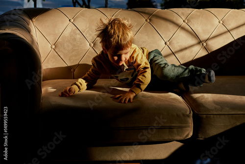 Little caucasian boy is playing in the hotel lobby by himself.