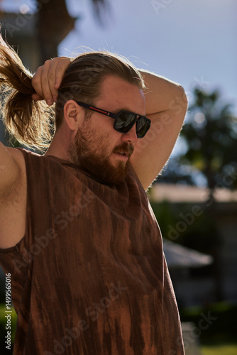 Man holding his hair in the sunlight