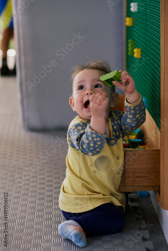 Little girl playing the constructor in the kid indoor  playground.