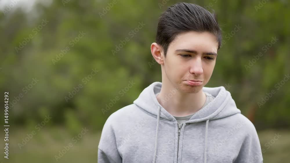 Sad sorrowful teenage boy grimacing in grief and sadness. Melancholy young man twisting his lips in sorrow and heartache. Downcast adolescent with pained expression showing deep sadness Sad sorrowful teenage boy grimacing in grief and sadness. Melancholy young man twisting his lips in sorrow and heartache. Downcast adolescent with pained expression showing deep sadness