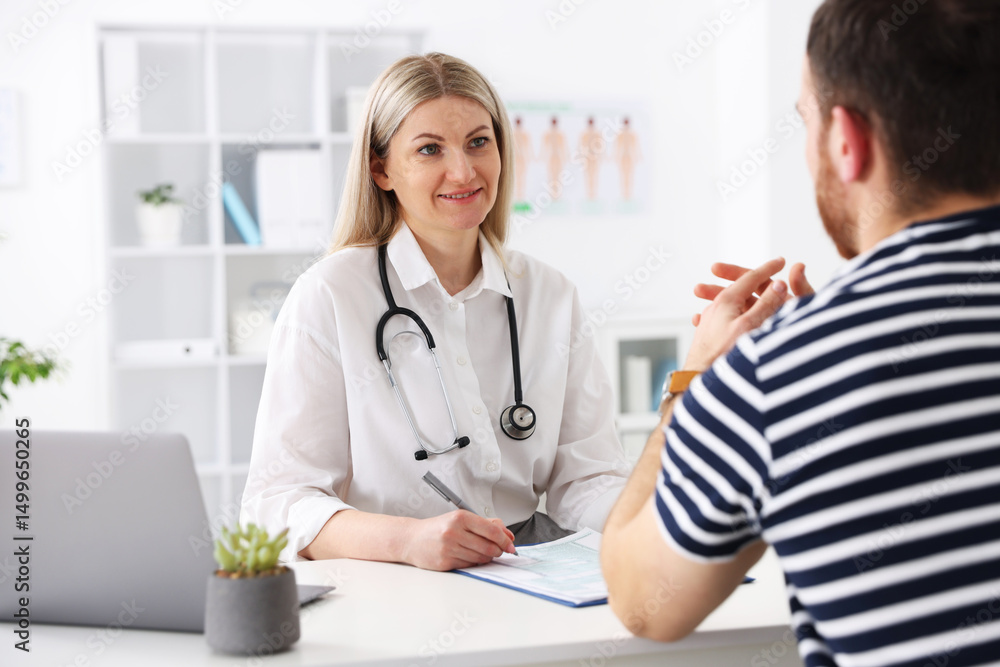 Doctor and her patient at desk in hospital Doctor and her patient at desk in hospital