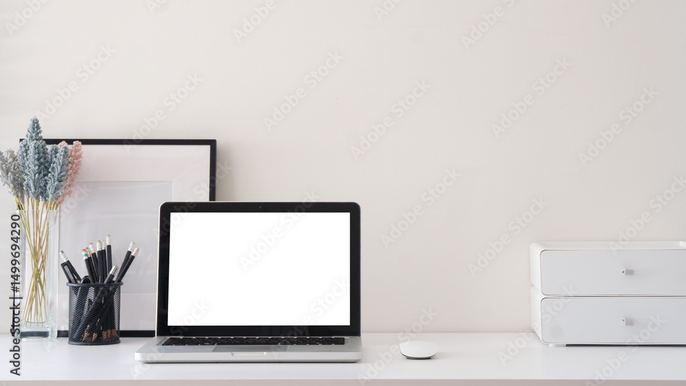 Simple home office with blank photo frame, stationery and laptop with blank screen for displaying mockups. Simple home office with blank photo frame, stationery and laptop with blank screen for displaying mockups.