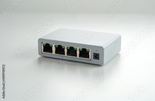 Small gray switch with ethernet ports. Networking tech for home office, small business. Ethernet, internet data transfer, local area network. Wireless network devices, connecting to internet. Data