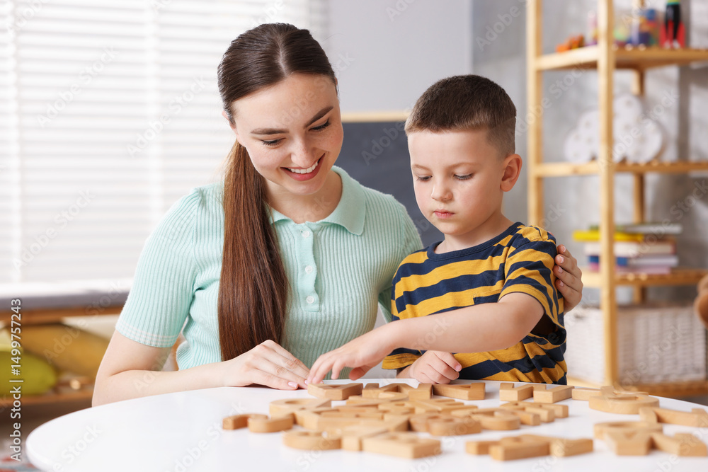 Obraz premium Dyslexia. Mother and her son learning letters at table indoors