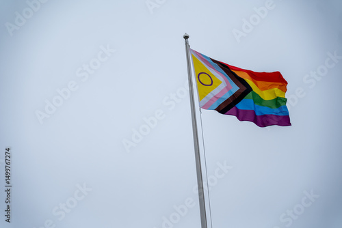 Pride Flag Displayed Proudly Against Pale Sky on Bright Day