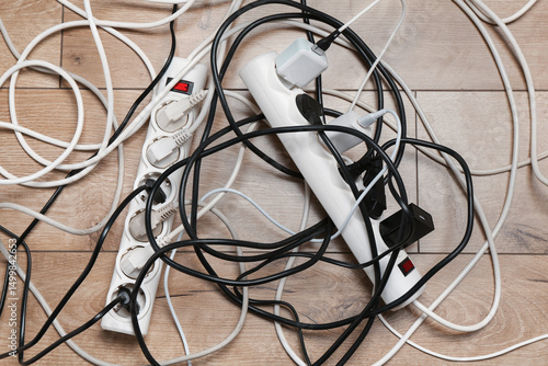 Canvastavla Extension power boards overloaded with plugs on wooden floor, top view
