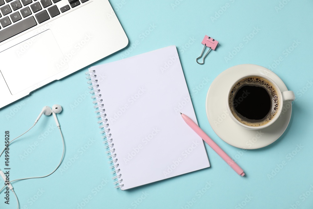 Fototapeta premium Notebook, pen, earphones, coffee, binder clip and laptop on light blue background, flat lay