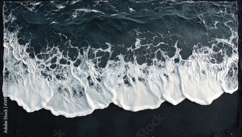 Dark ocean waves on black sand
