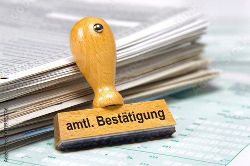 Ein Holzstempel ist beschriftet mit dem Aufdruck amtliche Bestätigung photo