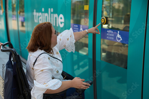 Woman in wheelchair using accessible public transport button - wheelchair and disability concept