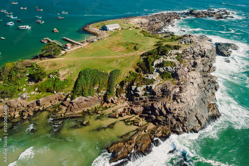 Fototapeta premium Rocky coastline with ocean and waves in Brazil. Drone view of Ponta das Campanhas in Floripa