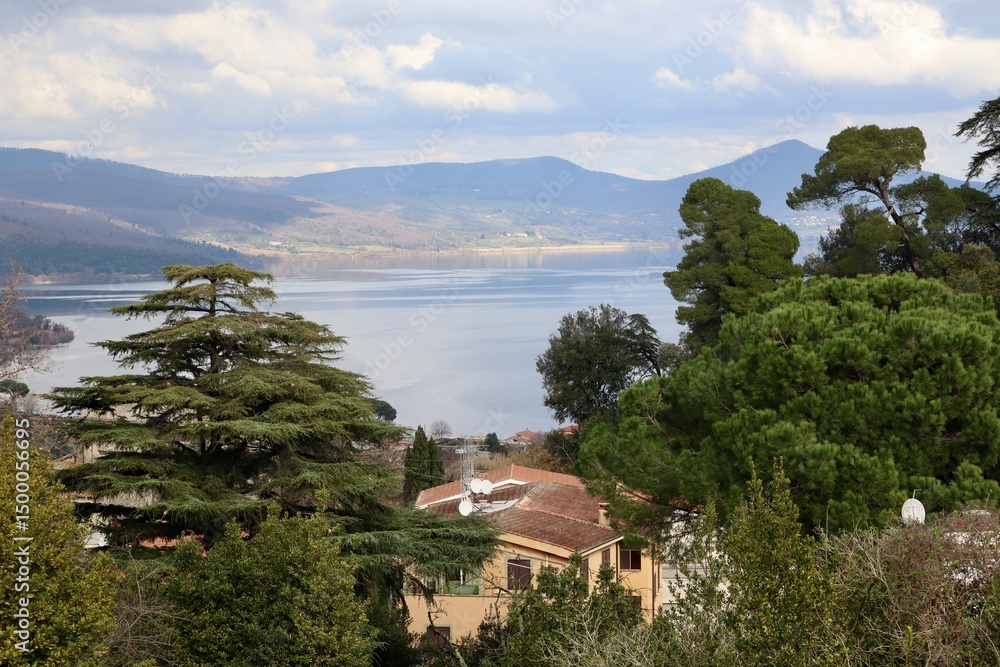 Fototapeta premium Panoramic View of Lake Bracciano Framed by Mediterranean Cypress and Village Rooftops