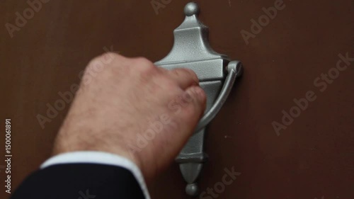 A closeup view of a salesman knocking on a house's front door. It opens.  	