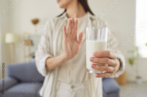 Canvastavla Woman with lactose intolerance or milk allergy holding glass of milk, doing stop gesture, saying no to gastrointestinal problems, sensitivity, dyspepsia, stomachache, bloating reaction