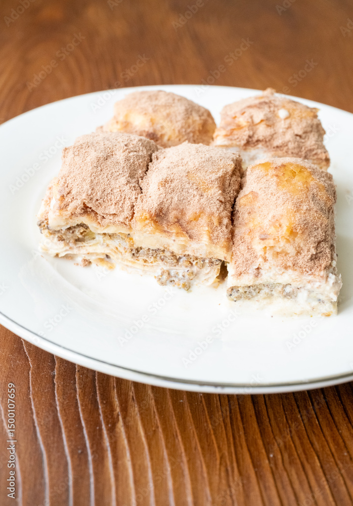Cold baklava with cacao on a white plate close up Cold baklava with cacao on a white plate close up