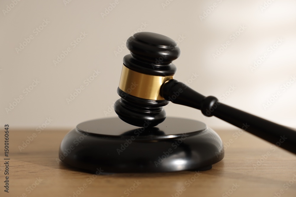 Judge's gavel on wooden table against light background, closeup Judge's gavel on wooden table against light background, closeup
