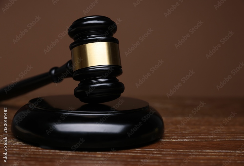 Judge's gavel and sound block on wooden table against brown background, closeup. Space for text Judge's gavel and sound block on wooden table against brown background, closeup. Space for text