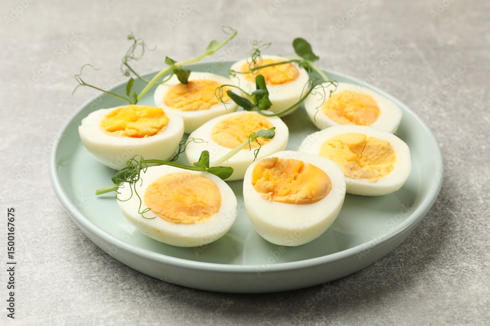 Hard boiled eggs with microgreens on grey table, closeup Hard boiled eggs with microgreens on grey table, closeup