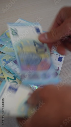 Euro banknotes counted on wooden table.Hands sorting and counting euro bills on a wooden surface, concept of budget planning and financial operations. Vertical video