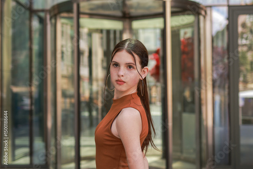 A girl with freckles in a leather skirt near a skyscraper. Free Download A girl with freckles in a leather skirt near a skyscraper. - GFXLoad