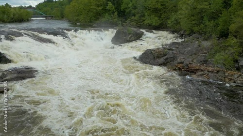 Aerial View of Flowing River with Foam Patterns and Forest Shoreline in Maine