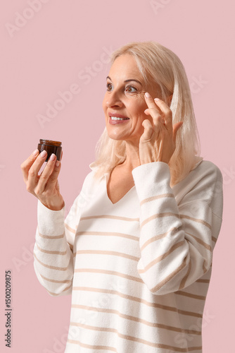 Mature woman applying cream...