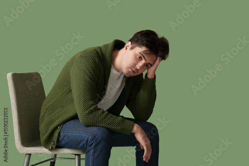 Depressed young man sitting...