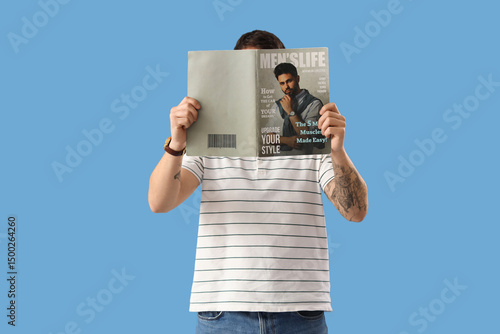 Handsome young man reading ...