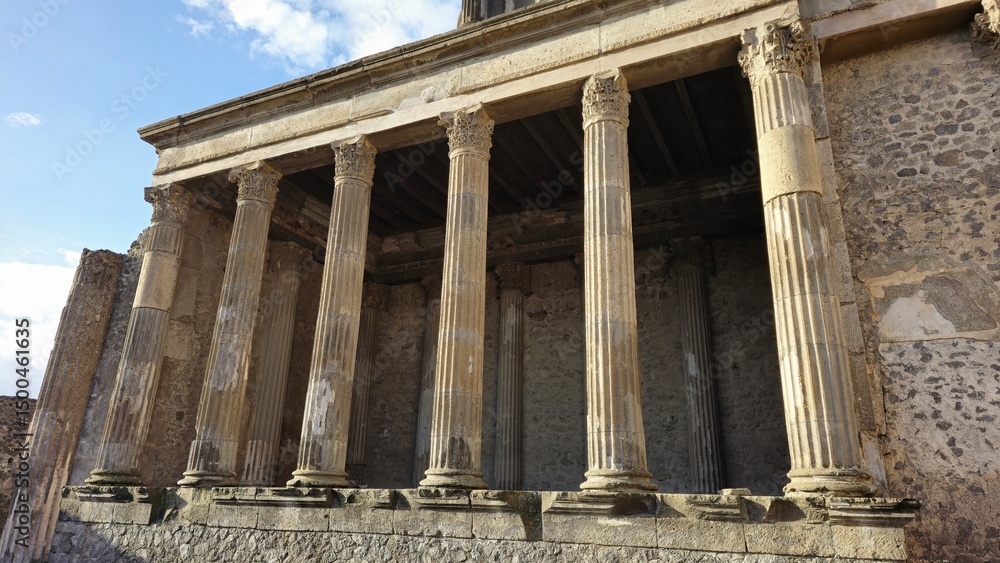 Obraz premium Pompeii, Italy - 8 January 2025. Close-up of the Basilica's main colonnade in Pompeii, Italy, showing tall fluted columns with Corinthian capitals and a partially intact entablature.