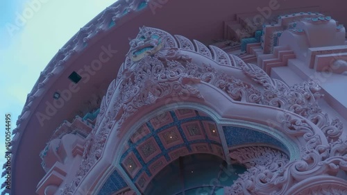 A pink pedestal decorated in traditional Thai style, on which stands the Three-Headed Erawan Elephant. Shot in motion