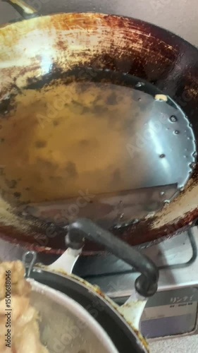 Frying pork fat to get oil for cooking and to get pork rinds to eat.
