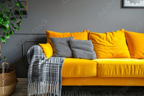 A cozy living room corner with a vibrant yellow sofa and contrasting grey throw pillows