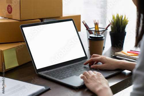 Hand using a computer laptop with a blank screen on table, for putting advertising to promote
