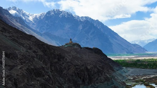 Aerial drone shot capturing the historic Diskit Monastery with its colorful prayer flags fluttering against mountain backdrops.