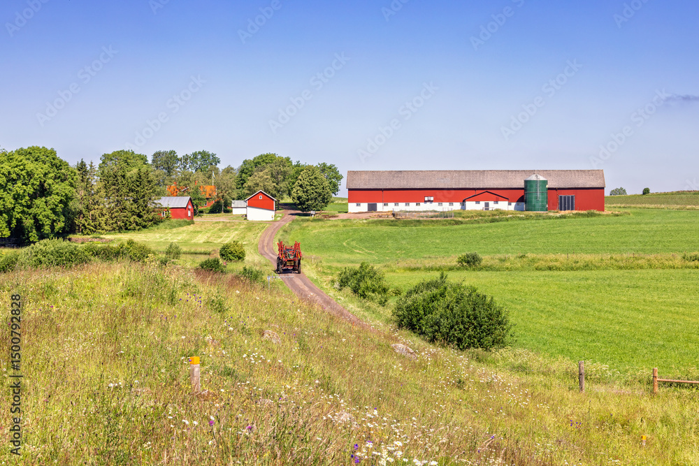 Idyllic rural landscape with a tractor on a dirt road on the way to the farm Idyllic rural landscape with a tractor on a dirt road on the way to the farm