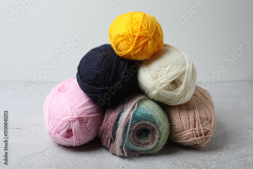 Skeins of yarn, knitting needles anwooden table, closeup